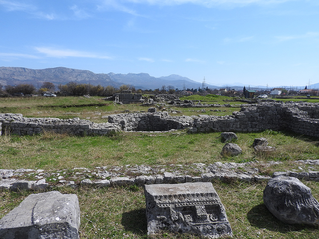 Photograph of the ruins of a room located on the east side of the forum of Doclea. The addition of an apse reflects later architectural modifications.
