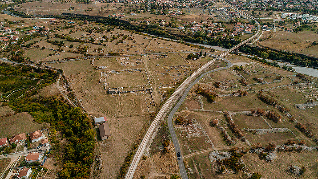 An aerial view of the archaeological site showing ruins scattered across an open landscape.