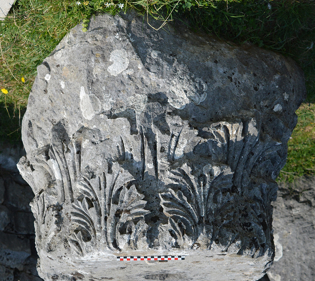 Close-up of a Corinthian capital adorned with finely carved vegetal motifs. This type of architectural element was typical of elegant and refined Roman constructions.